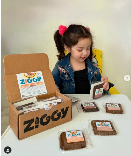A girl holding Snack Bar from Ziggy Bars delivery box